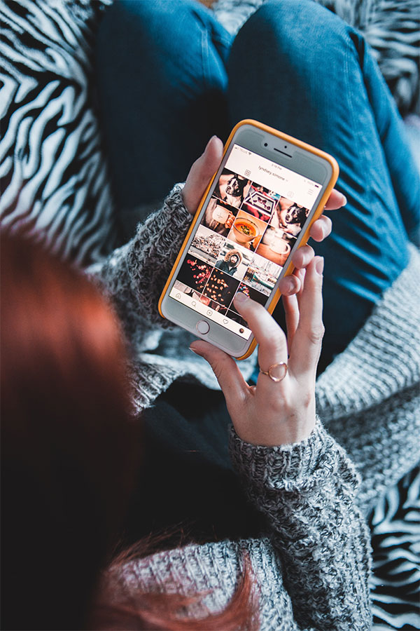 A woman viewing various pictures on a smartphone.